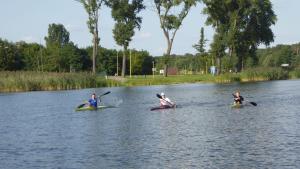 3 osoby pływają kajakiem po rzece w obiekcie Sommerhaus am See w Ślesinie