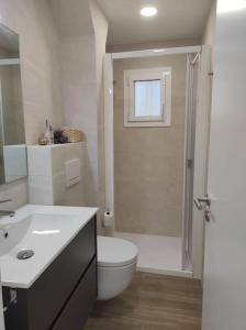 Un baño con inodoro, lavabo y ducha. en Apartamento Reformado con Aparcamiento. Playa 5min a pie., en Platja d'Aro