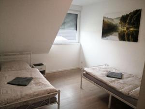 two beds in a room with a window at Beautiful Maisonette in Mörfelden-Walldorf in Mörfelden-Walldorf
