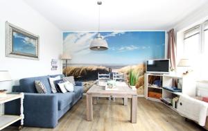 ein Wohnzimmer mit einem blauen Sofa und einem Tisch in der Unterkunft Beach Ole in Hörnum