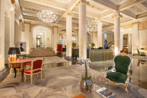a lobby with a table and chairs in a building at Grand Hotel Et Des Palmes in Palermo