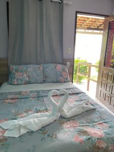 Dos cisnes hechos de toallas en una cama en Pousada Moryah, en Paripueira