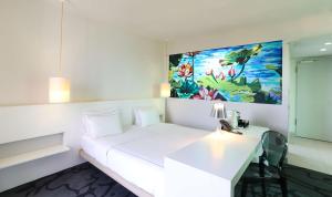 una camera con un letto bianco e un dipinto sul muro di art'otel cologne, Powered by Radisson Hotels a Colonia