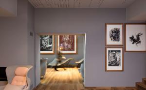 art'otel berlin mitte, Powered by Radisson Hotels في برلين: غرفة معيشة مع العديد من الصور على الحائط