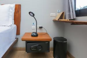 a room with a bed and a desk with a lamp at Damar Toba in Balige