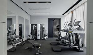 a gym with several treadmills and machines in a room at Park Plaza London, Park Royal in London