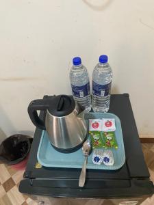a tea kettle and two bottles of water on a stove at Calangute Beach Palms in Calangute