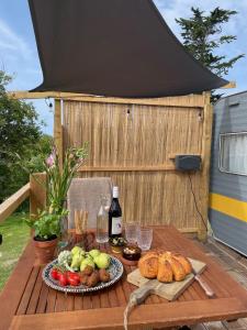 a table with food and a bottle of wine at Puckaster Cove Garden Yurt in Niton