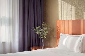 a vase of flowers on a table next to a bed at Park Plaza Nottingham in Nottingham