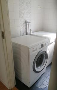 a washer and dryer in a small room at Sosa's villa. (Free Coffee, BBQ & Garden Fruits) in Turku