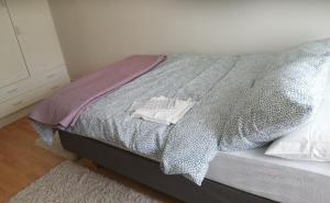 ein Schlafzimmer mit einem Bett mit einer grauen Bettdecke in der Unterkunft Sosa's villa. (Free Coffee, BBQ & Garden Fruits) in Turku