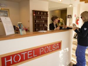 dwie kobiety stojące przy hotelowym pollka ladzie w obiekcie Hotel Polsa w mieście Brentonico