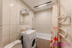 a bathroom with a sink and a washing machine at Двухкомнатные фирменные апартаменты Тиффани in Petropavlovsk