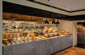 a restaurant with a counter with food on it at Park Plaza Vondelpark Amsterdam in Amsterdam