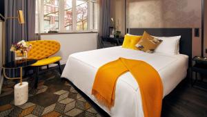 a bedroom with a large bed and a yellow chair at Park Plaza Vondelpark Amsterdam in Amsterdam