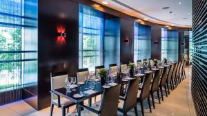 伦敦Park Plaza London Westminster Bridge的长长的用餐室配有长桌子和椅子 更多37张照片