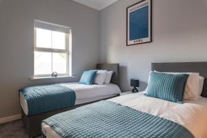 um quarto com 2 camas e uma janela em Stunning 2BR, 2BA, Apartment - Super King Size Beds - Free Parking - 6 mins to LGW Airport em Crawley