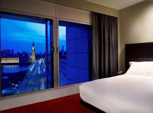 a bedroom with a large window with a view of a city at Park Plaza London Westminster Bridge in London