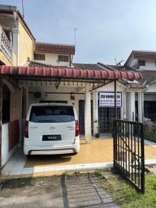 um carro branco está estacionado numa garagem em ZZR Homestay em Kampong Tanah Merah