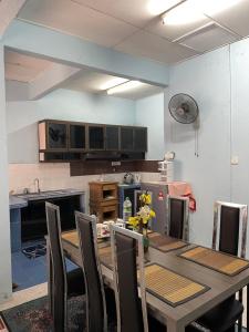 cocina con mesa y sillas en una habitación en ZZR Homestay, en Kampong Tanah Merah