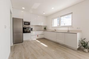 an empty kitchen with white cabinets and a window at Villa Patricia in Santa Barbara