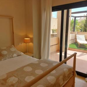 a bedroom with a bed and a view of a patio at Un Oasis en Hacienda del Álamo in Murcia