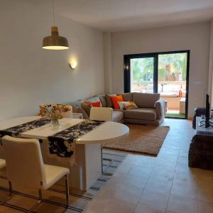 een woonkamer met een tafel en een bank bij Un Oasis en Hacienda del Álamo in Murcia