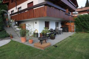 a house with a patio with a table in the yard at Studio der Alpen in Thun