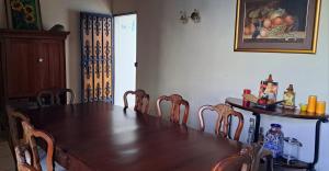 a dining room table and chairs with a table and a table and a table at Kartagus Guest House in San Salvador