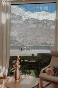 a room with a window with a view of a mountain at Stunning and Modern House On The Lake in Quarten