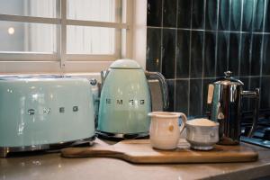 a kitchen counter with a toaster and cups on a cutting board at The Oyster Shack by The Oyster Collection in Kenton on Sea