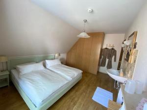 a small bedroom with a bed and a sink at Gästezimmer Neumair in Undeloh