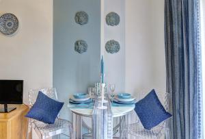 a dining room with a white table and chairs at SuiteHome Taormina in Giardini Naxos