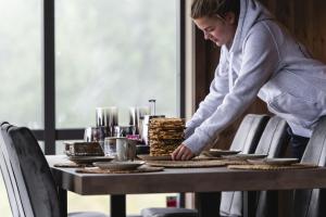 Uma mulher de pé sobre uma mesa com comida. em Ski inn-ski ut hytte i Aurdal - helt ny em Aurdal