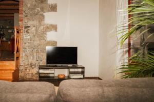 a living room with a tv and a couch at Holiday Home GaMaJaMa in Dobravlje
