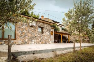 una casa de piedra con un porche delante en Holiday Home GaMaJaMa en Dobravlje