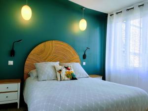 a bedroom with a large bed with blue walls at La Waide in Amiens