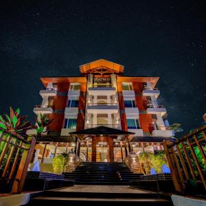 a hotel with stairs leading up to it at night at Godwin Goa in Candolim