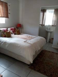 a bedroom with a bed and a sink at Lor's Place in Mount Road