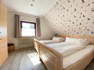 ein Schlafzimmer mit einem Bett und einer Wand mit Blättern darauf in der Unterkunft Ferienwohnung Neumair in Undeloh
