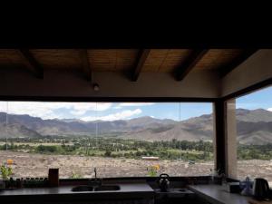a kitchen window with a view of the mountains at Cabaña Abra del Monte Monohambiente in Cachí
