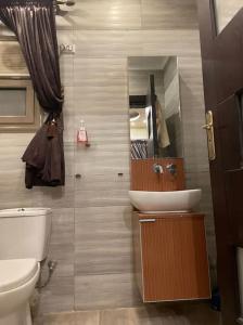 uma casa de banho com um WC branco e um lavatório. em Luxury Duplex 450m 4BR For Familias no Cairo