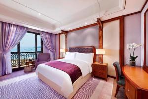 a hotel room with a bed and a desk and window at The Ritz-Carlton Jeddah in Jeddah