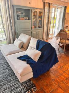 - un canapé blanc avec une couverture bleue dans le salon dans l'établissement Gite Gilles, au Palais