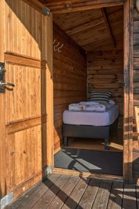 Cabaña de madera con cama en la puerta en Hlíd Huts en Myvatn