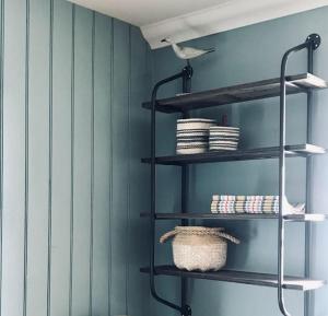 a room with black shelves in a blue wall at Harbour Side, Luxury, Twin Level Loft in Burghead