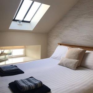 a bedroom with a large white bed with a skylight at Harbour Side, Luxury, Twin Level Loft in Burghead