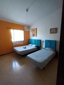 Habitación con 2 camas y ventana en Lagarto Hostel Tenerife, en Valle de Guerra