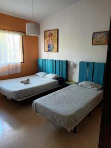 2 camas en una habitación decorada en tonos azules en Lagarto Hostel Tenerife en Valle de Guerra