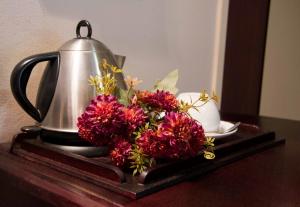 ein Tablett mit einem Wasserkocher und Blumen auf dem Tisch in der Unterkunft Zoete Rust Boutique Hotel in Lephalale